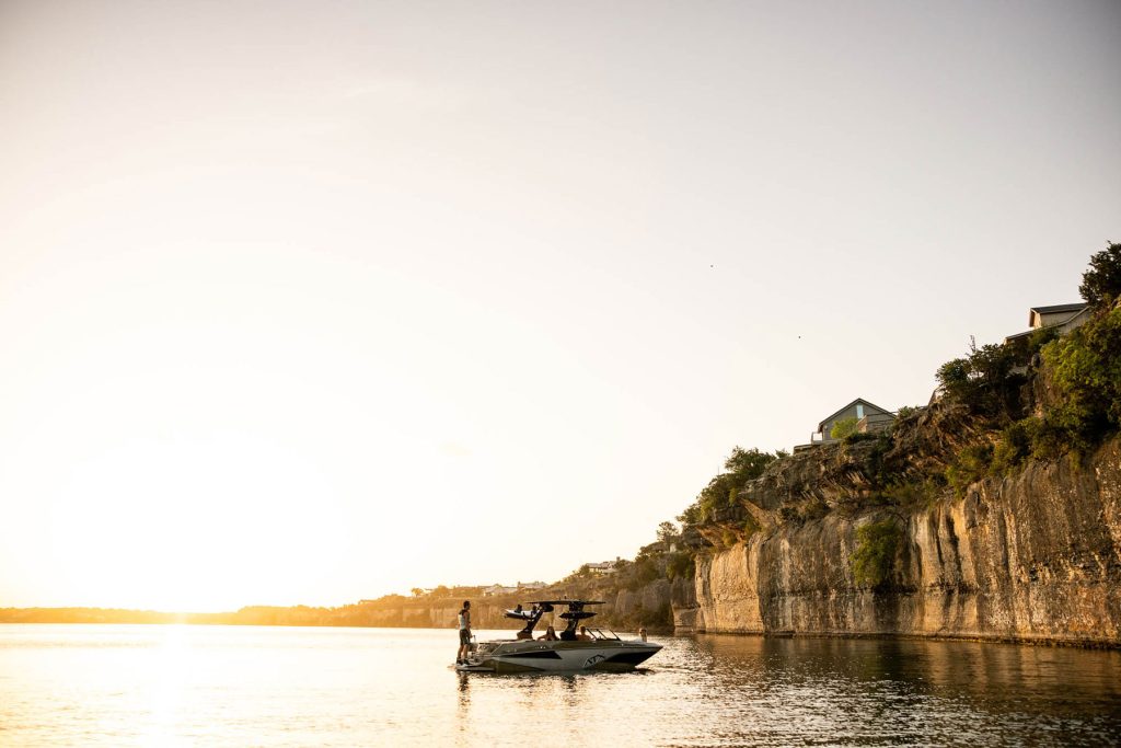 A boat peacefully floating in the water as the sun sets, at Young Harris Watersports & RV.